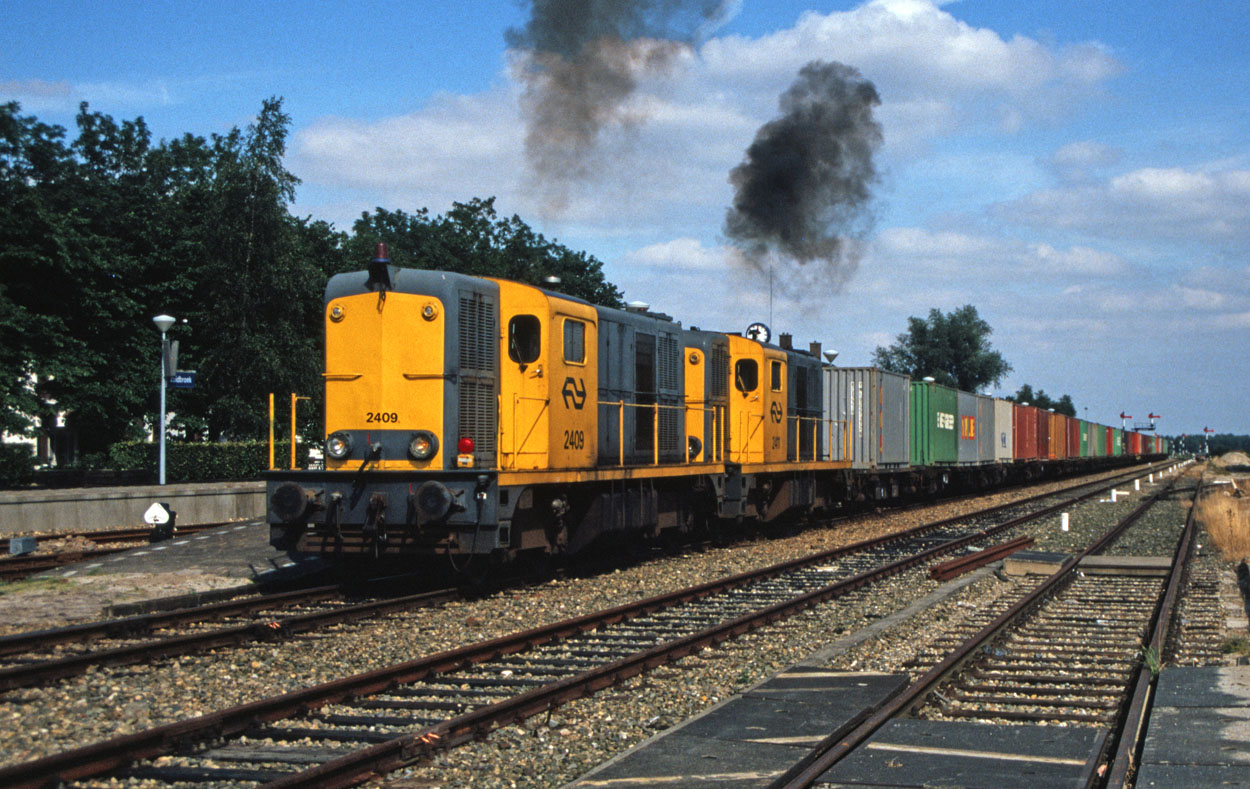 NS 2409 and 2411 accelarate out of Zuidbroek (NL) with a container train from Veendam (NL) to Maasvlakte (NL) in the summer of 1989.